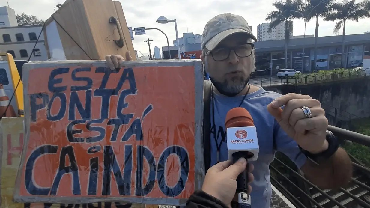 (V&Iacute;DEO) Homem protesta pela situa&ccedil;&atilde;o de pontes usando cartaz e caix&atilde;o