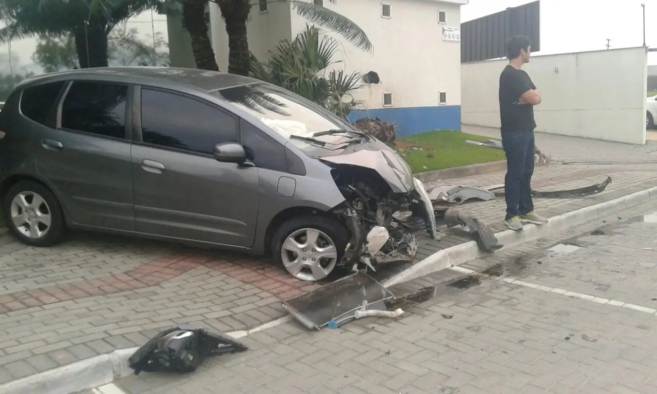 Carro tem frente destruída após colisão contra prédio