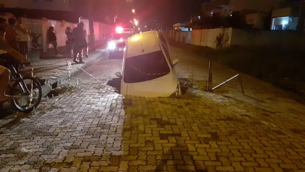 Carro &eacute; "engolido" por buraco que se abre no meio da rua