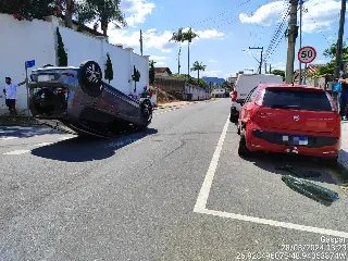 Carro bate em veículo estacionado e capota - 1