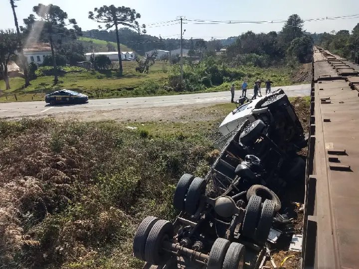 Carreta se choca contra trem e tomba na rodovia