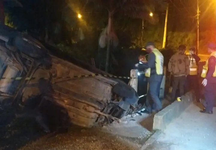 Carro fica pendurado sobre ponte com quatro dentro