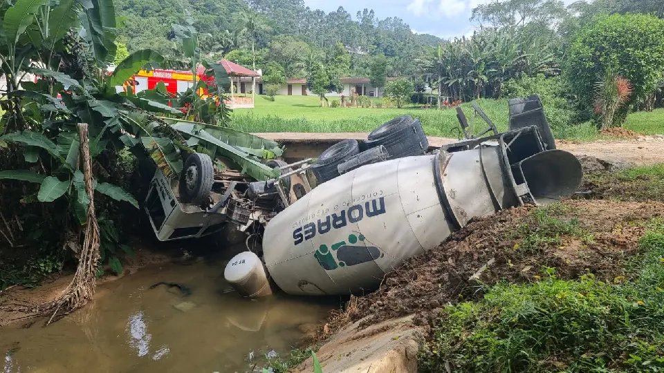 Caminhão tomba e motorista fica preso nas ferragens