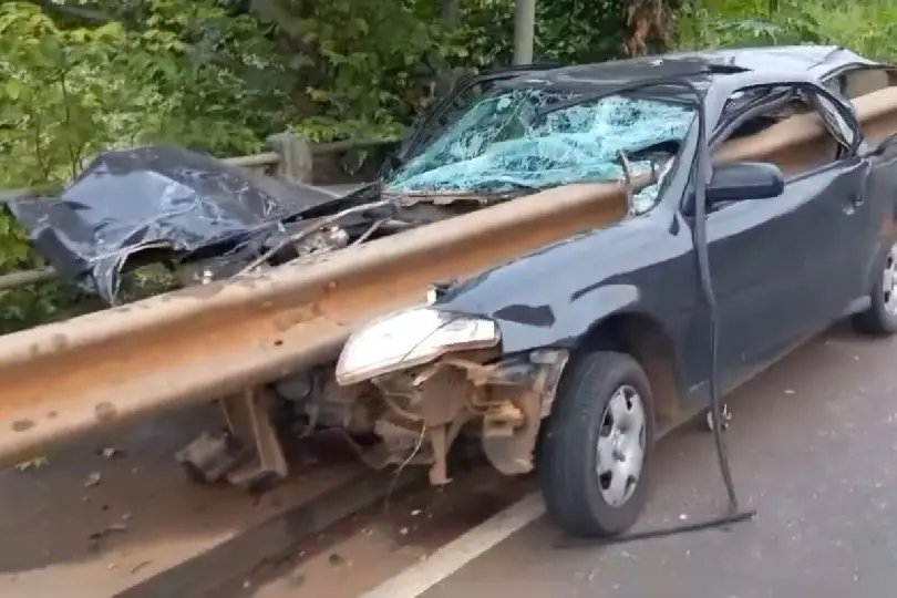 Carro é atravessado por guard-rail após colisão e ocupantes sobrevivem 